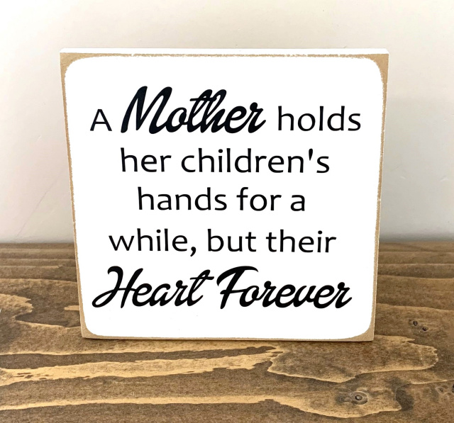 "A Mother holds her childrens hands..."